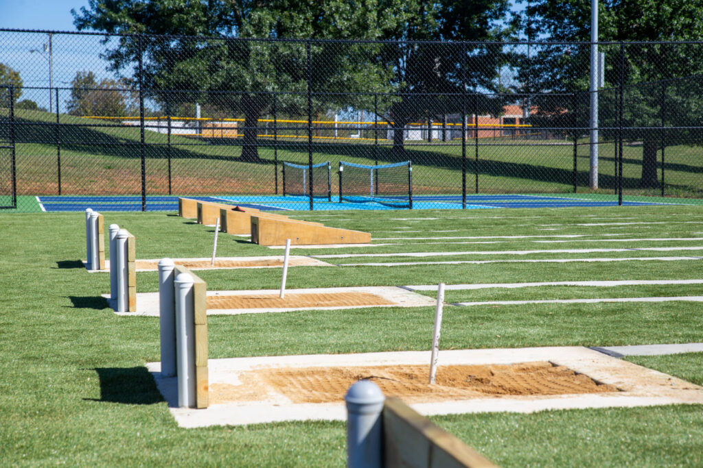 Looking at a closeup of the horseshoe pits and the pickleball courts in the distance.